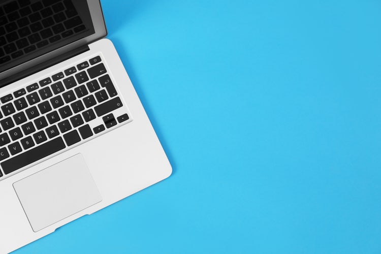 the corner of a laptop from a bird's eye view on a blue background
